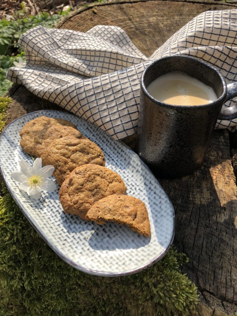Cookies med chokolade og lakrids og en kop kaffe i skovbunden