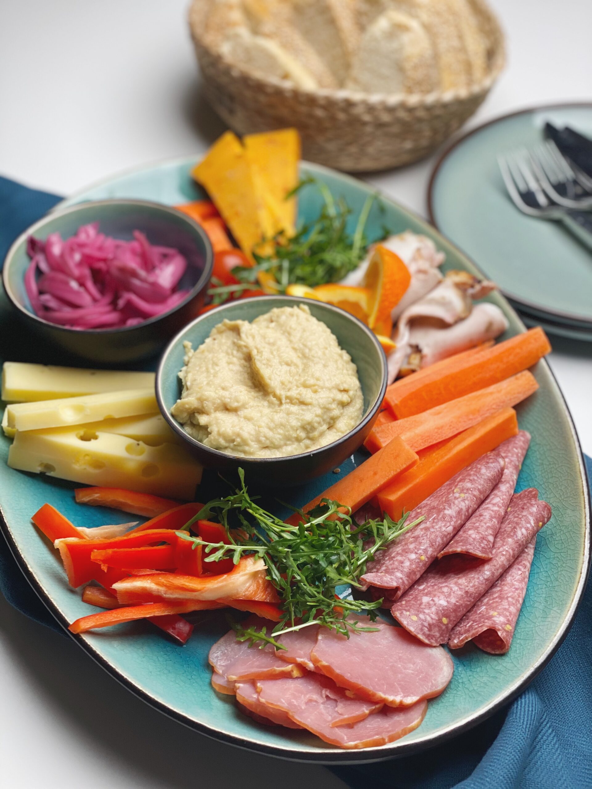 Humus som tilbehør på et fad med ost og pålæg