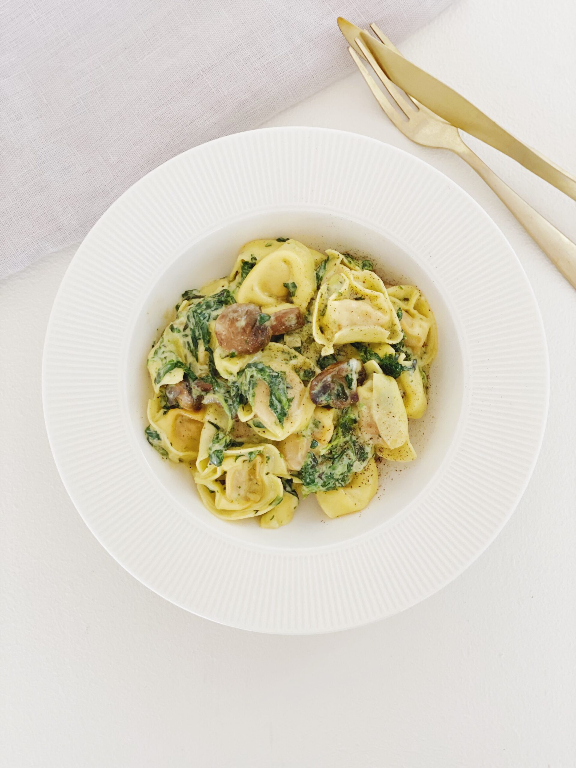 Tortellini-ret ,ed spinat og svampe set fra oven