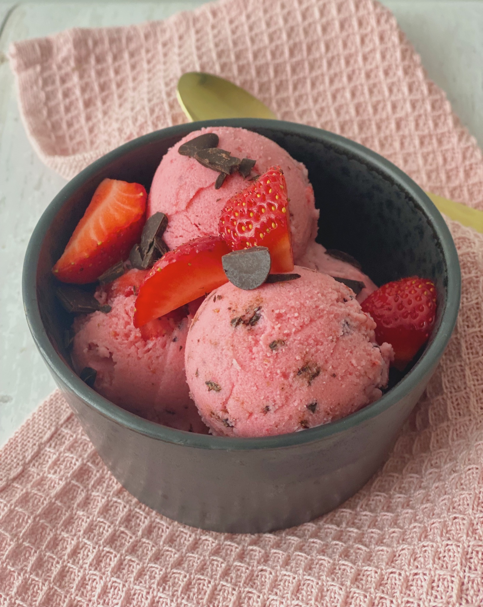 Kugler af frozen yoghurt med jordbær og chokoladestykker i en skål