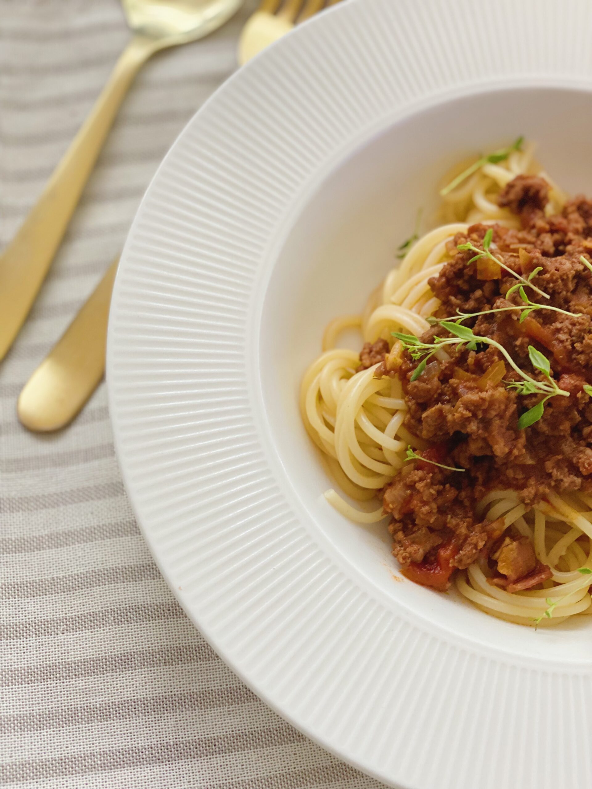 Spaghetti bolognese set tæt på og hvor du kun kan se den ene halvdel af tallerkenen