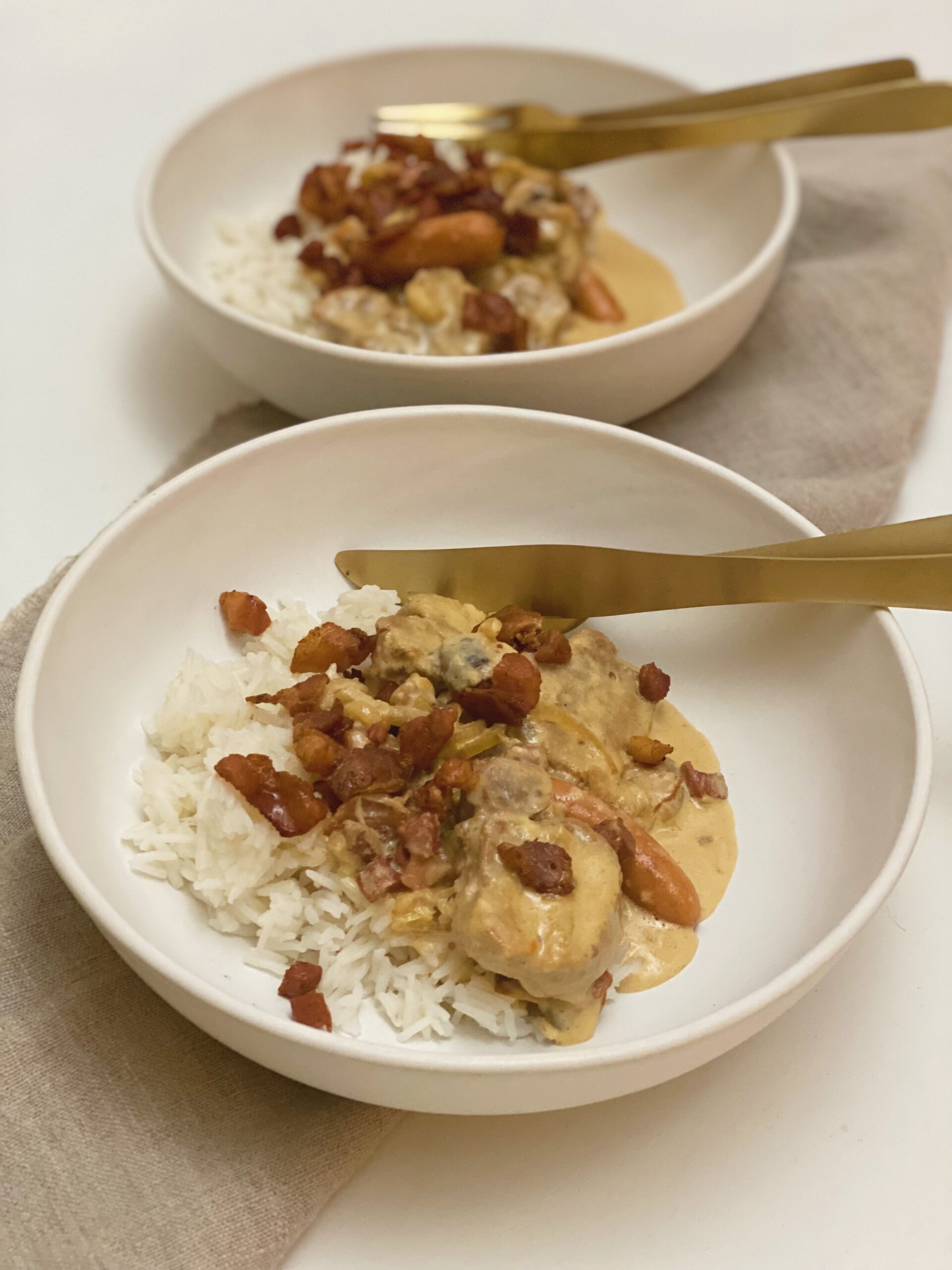 To portioner mørbrad ala creme serveret i dybe tallerkner med kogte ris til. Der er bestik af "guld" som ligger i tallerkenen